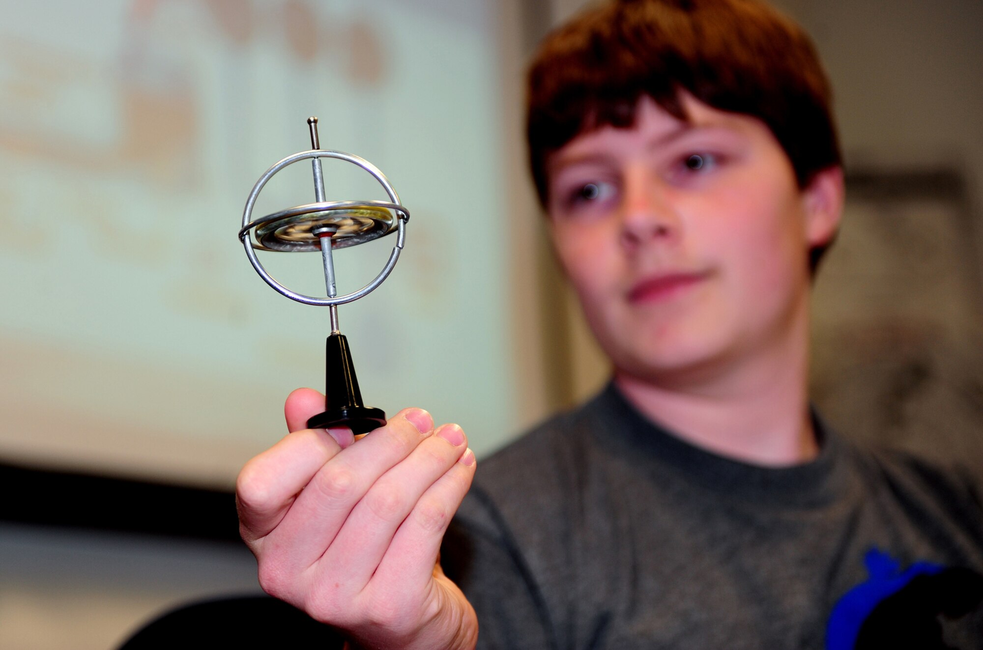 OFFUTT AIR FORCE BASE, Neb. -- Nolan Raper, a 14-year-old Bellevue resident, holds a ?gyro? toy while learning how the instruments pilots use during flight work, during Aviation Opportunities Day hosted by the LeMay Aero Club here May 15.  Those who attended the event were given hands on training on how to prep an aircraft for preflight and instrument instructions. Attendees were also given aircraft tours and a one hour introductory flight with an instructor. U.S. Air Force Photo by Josh Plueger 
