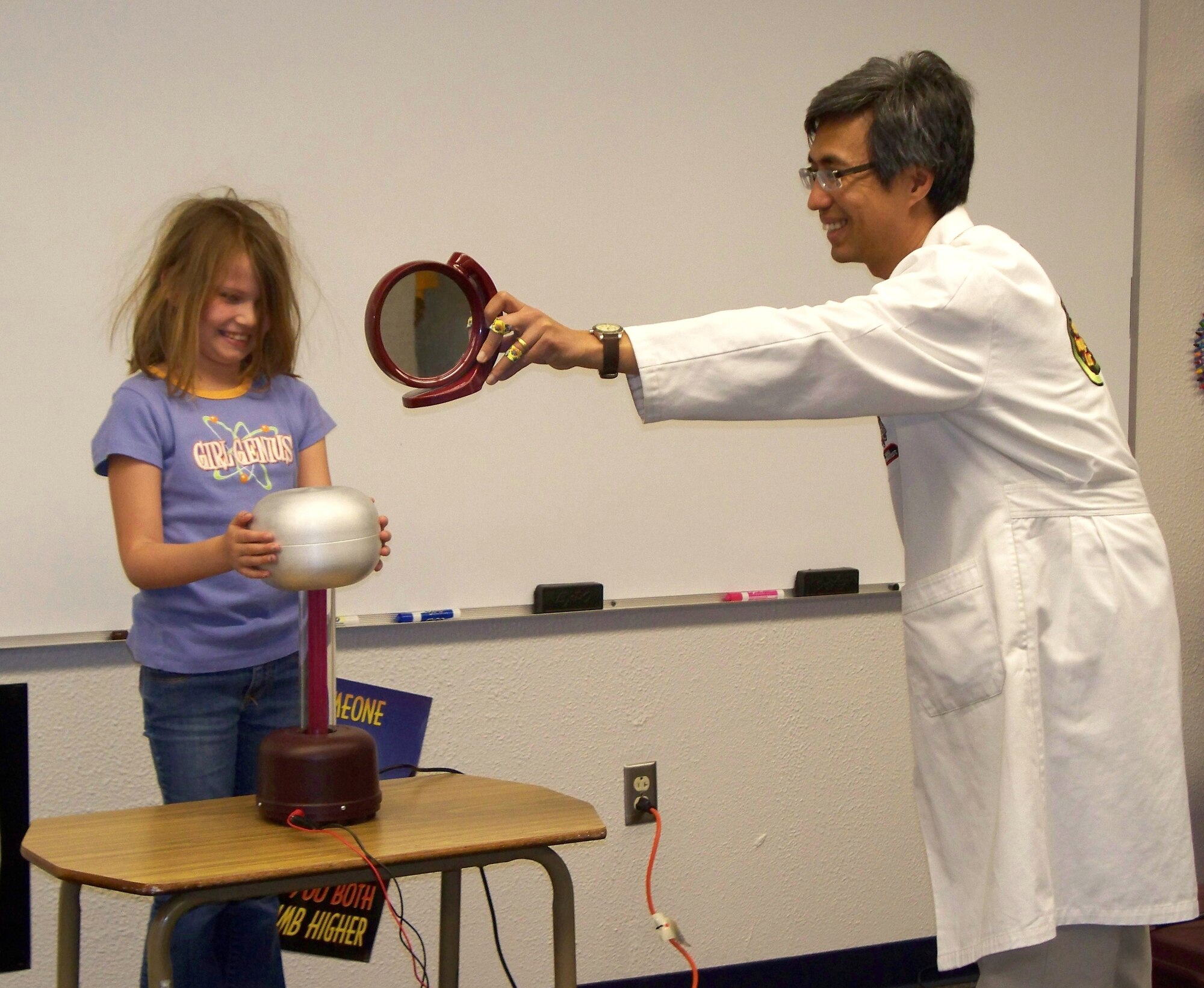 HOLLOMAN AIR FORCE BASE, N.M. -- Dr. Ken Cheung, the director and owner of the Mad Science Company in El Paso, Texas, performs a science experiment with Season Bibeault, daughter of Tech. Sgt. Joseph Bibeault, 4th Space Control Squadron, during a Mad Science Workshop at the Holloman Middle School April 5, 2010. The Airman and Family Readiness Center hosted the workshop for military kids from kindergarten to eighth grade. Holloman children learned about Kinetic and Potential Energy, did hands-on experiments and performed an assembly for family members and friends. (Courtesy photo / Released)