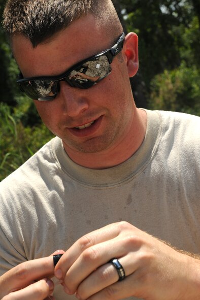 MOODY AIR FORCE BASE, Ga. -- Staff Sgt. Kyle Miller, 23rd Equipment Maintenance Squadron munitions craftsman, puts lubrication on a back-cap before firing the percussion actuated neutralizer device here May 12. The back-cap prevents water from leaking down to the round and causing the PAN device to misfire. (U.S. Air Force photo by Airman 1st Class Benjamin Wiseman/RELEASED)