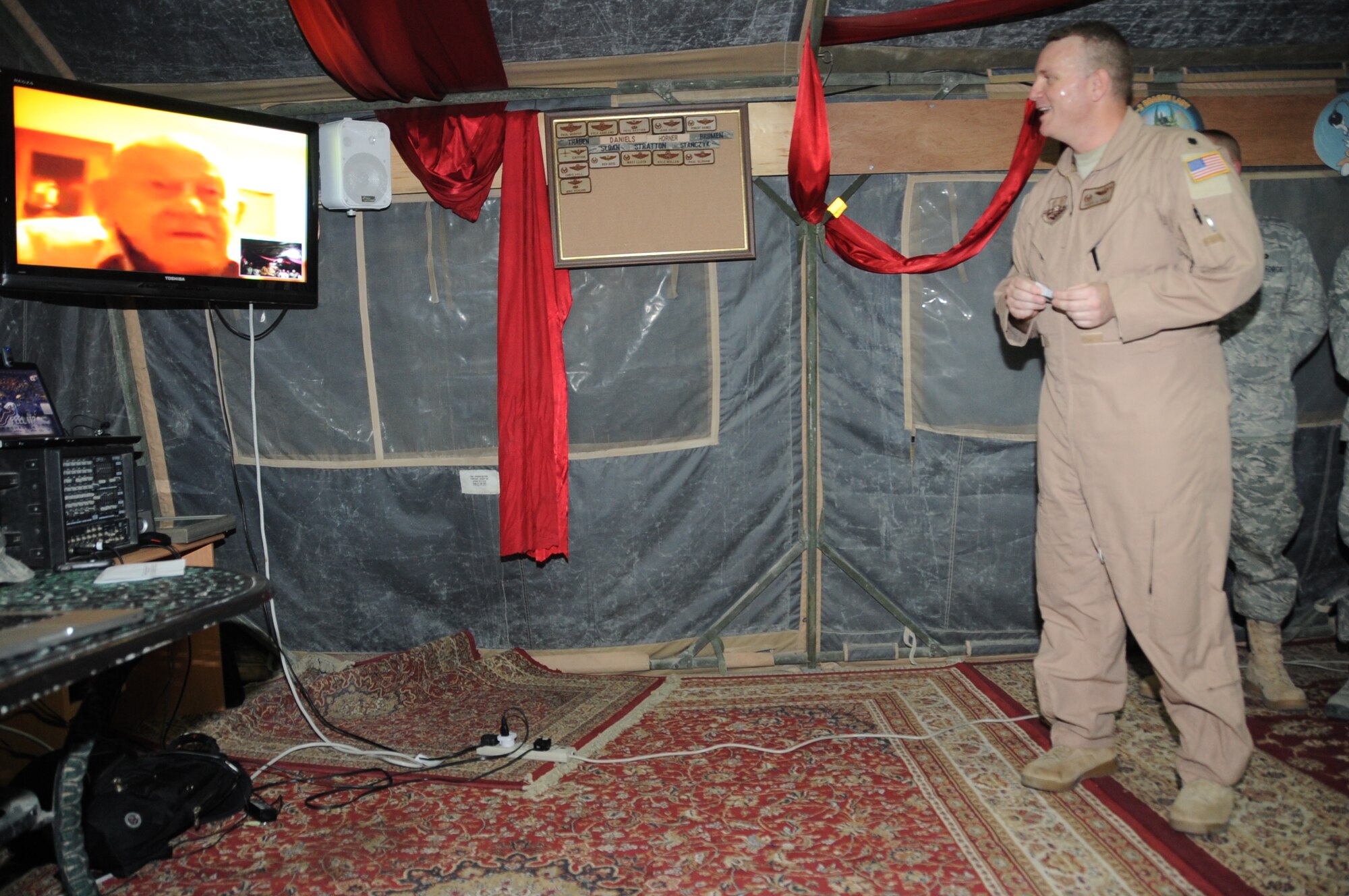 Lt. Col. Daryl Page, 380th Expeditionary Operations Support Squadron commander, talks via video teleconference with retired Lt. Col. Robert Weaver, a former B-24 Liberator pilot during World War II with the 380th Bombardment Group, during a special presentation by Colonel Page and other 380th AEW members honoring 380th BMG veterans May 12, 2010, at a non-disclosed base in Southwest Asia. (U.S. Air Force Photo/Senior Airman Jenifer H. Calhoun/Released)