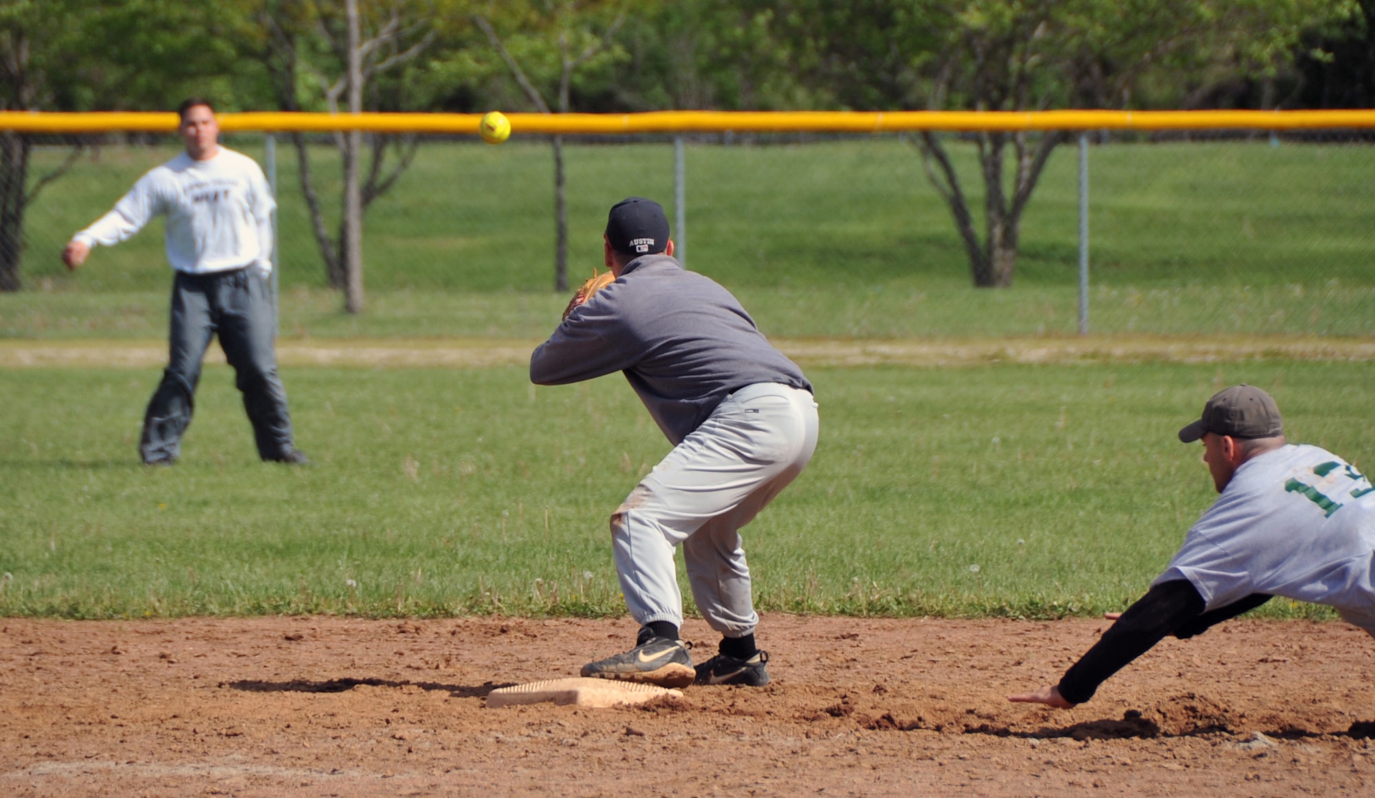 OFFUTT AIR FORCE BASE, Neb. -- Matt Austin for the Omaha Police Department, waits for the ball to tag out Tech Sgt. Michael Logan, 55th Security Forces Squadron, as he slides head first into second base during Offutt's Police Week Softball Tournament here May 13. The tournament was one of Offutt's many events in observance of National Police Week which also included a static weapons display, military working dog demonstration and a retreat ceremony. U.S. Air Force Photo by Jeff W. Gates.