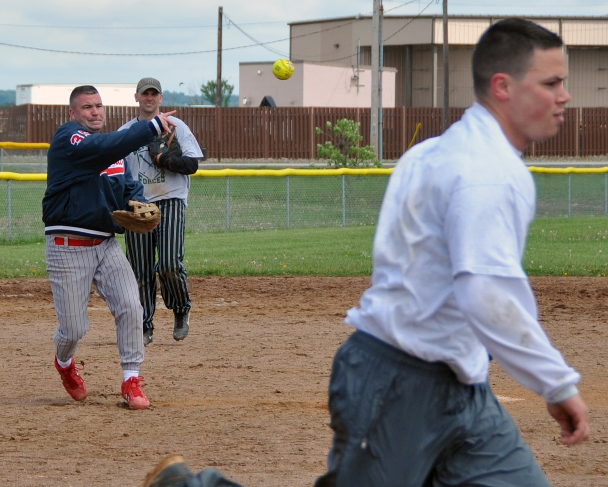OFFUTT AIR FORCE BASE, Neb. -- Master Sgt. Henry Brown, 55th Security Forces Squadron, throws the ball to first base in an attempt to get a base runner out during Offutt's Police Week Softball Tournament here May 13. The tournament was one of Offutt's many events in observance of National Police Week which also included a static weapons display, military working dog demonstration and a retreat ceremony. U.S. Air Force Photo by Jeff W. Gates