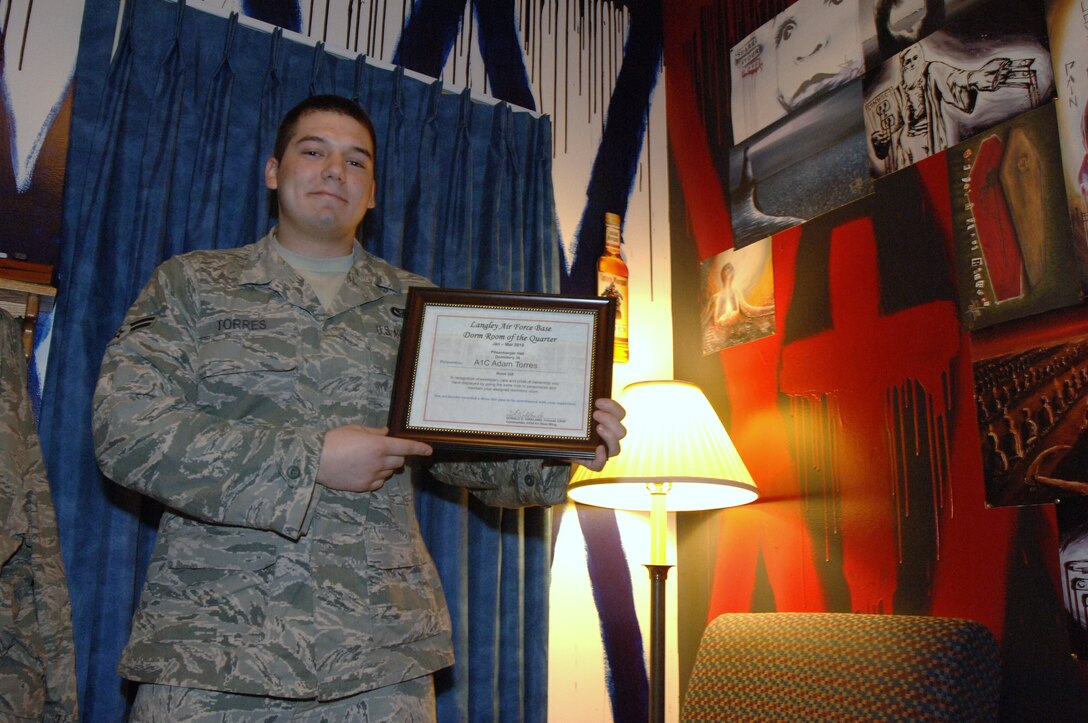 LANGLEY AIR FORCE BASE, Va. -- Airman 1st Class Adam Torres, 633d Civil Engineer Squadron electrical power production technician, displays his Room of the Quarter award in his room at Pitsenbarger Hall May 13. Torres won the award for his unique and artistic painting and decoration, which afforded him a three-day pass. (U.S. Air Force photo/Airman 1st Class Jason J. Brown)