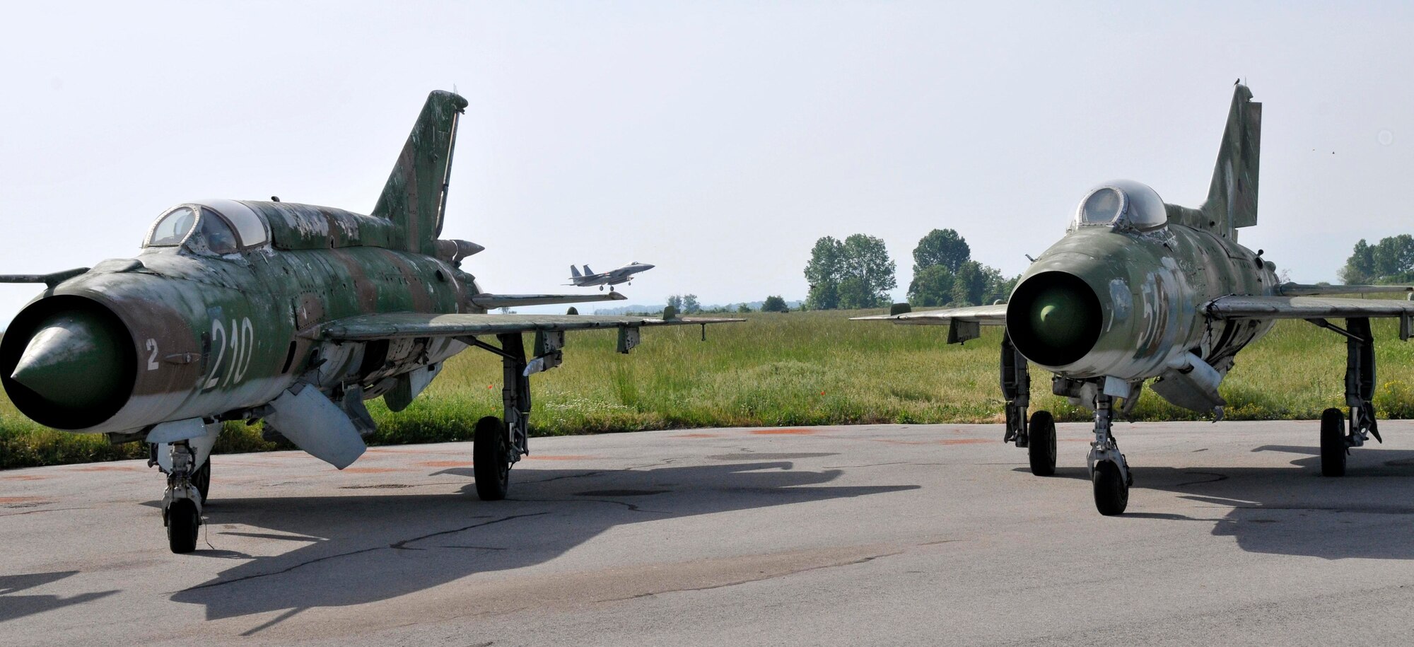 GRAF IGNATIEVO AIR FORCE BASE, Bulgaria - An F-15 from the 493rd Fighter Squadron at RAF Lakenheath, England, lands at Graf Ignatievo Air Force Base in Plovdiv, Bulgaria, May 13, with two MiG-21s parked in the foreground. Airmen from the 48th Fighter Wing are in Bulgaria taking part in Sentry Gold, an exercise developed to familiarize U.S. pilots with the MiG airframes, build partnerships with the Bulgarian air force and assist them in their continued integration into NATO operations.