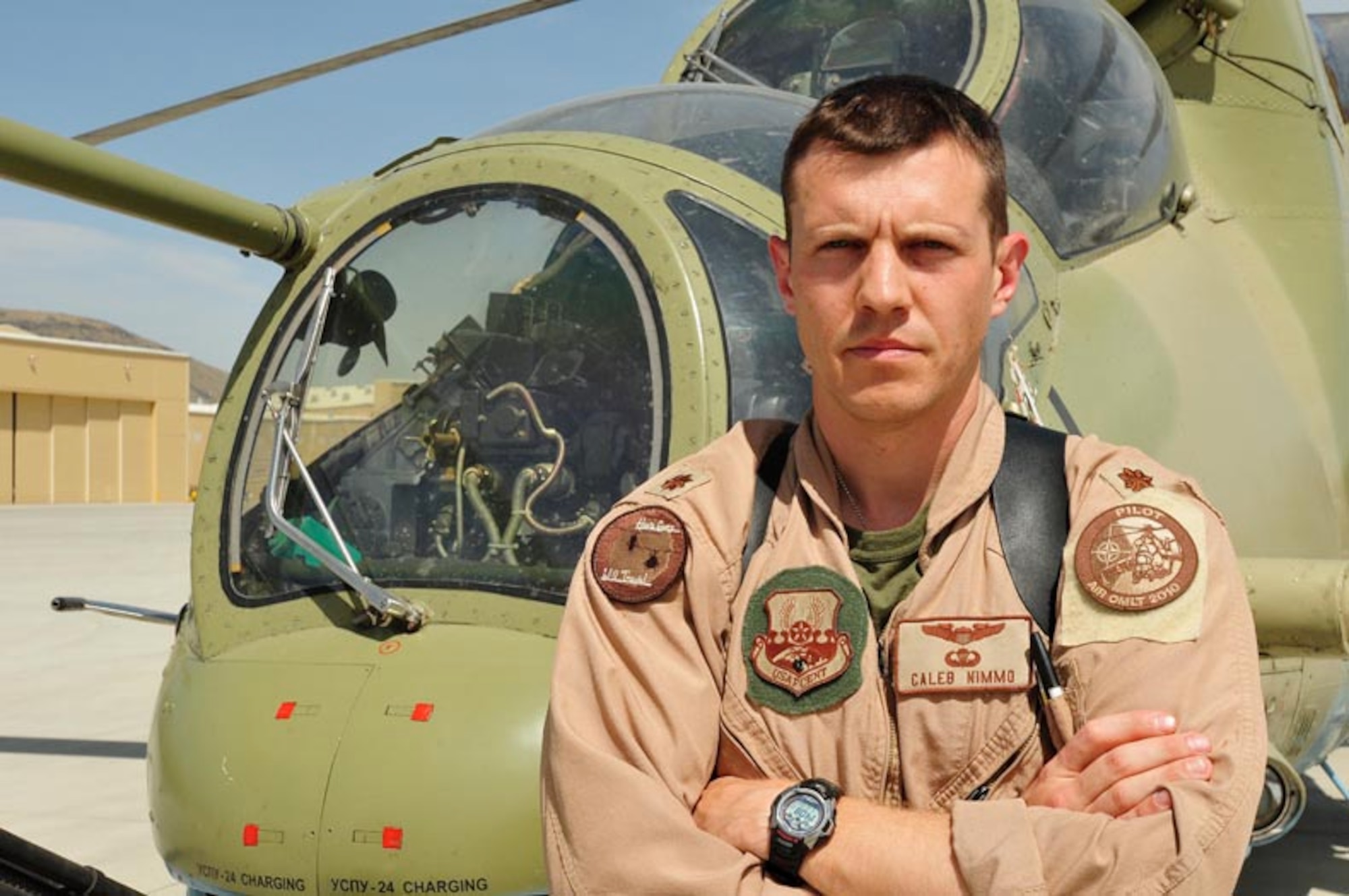Major Caleb Nimmo of the 438 Air Expeditionary Wing, Combined Air Power Transition Force, poses next to a Russian made Mi-35 attack helicopter at the Afghan National Army Air Corps base in Kabul, Afghanistan. (U.S. Navy photo by Mass Communications Specialist 1st Class (AW) Elizabeth Burke/RELEASED)