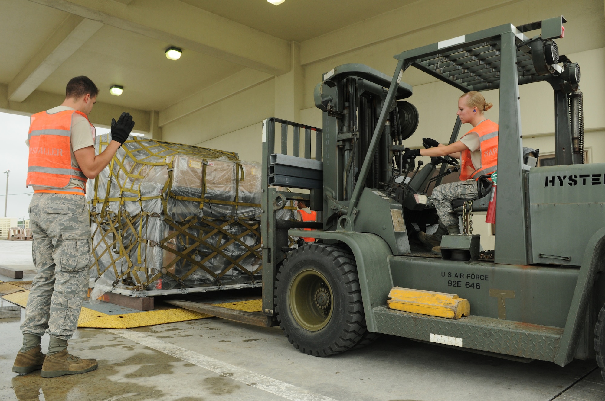 Airman 1st Class Hunter Roden guides A1C Tammy Walbolt as she aligns her
fork lift with a cargo pallet at Kadena Air Base, Japan, May 17, 2010.
Airmen Roden and Walbolt are members of the 18th Logistics Readiness
Squadron.  (U.S. Air Force photo/Staff Sgt. Christopher Hummel)
