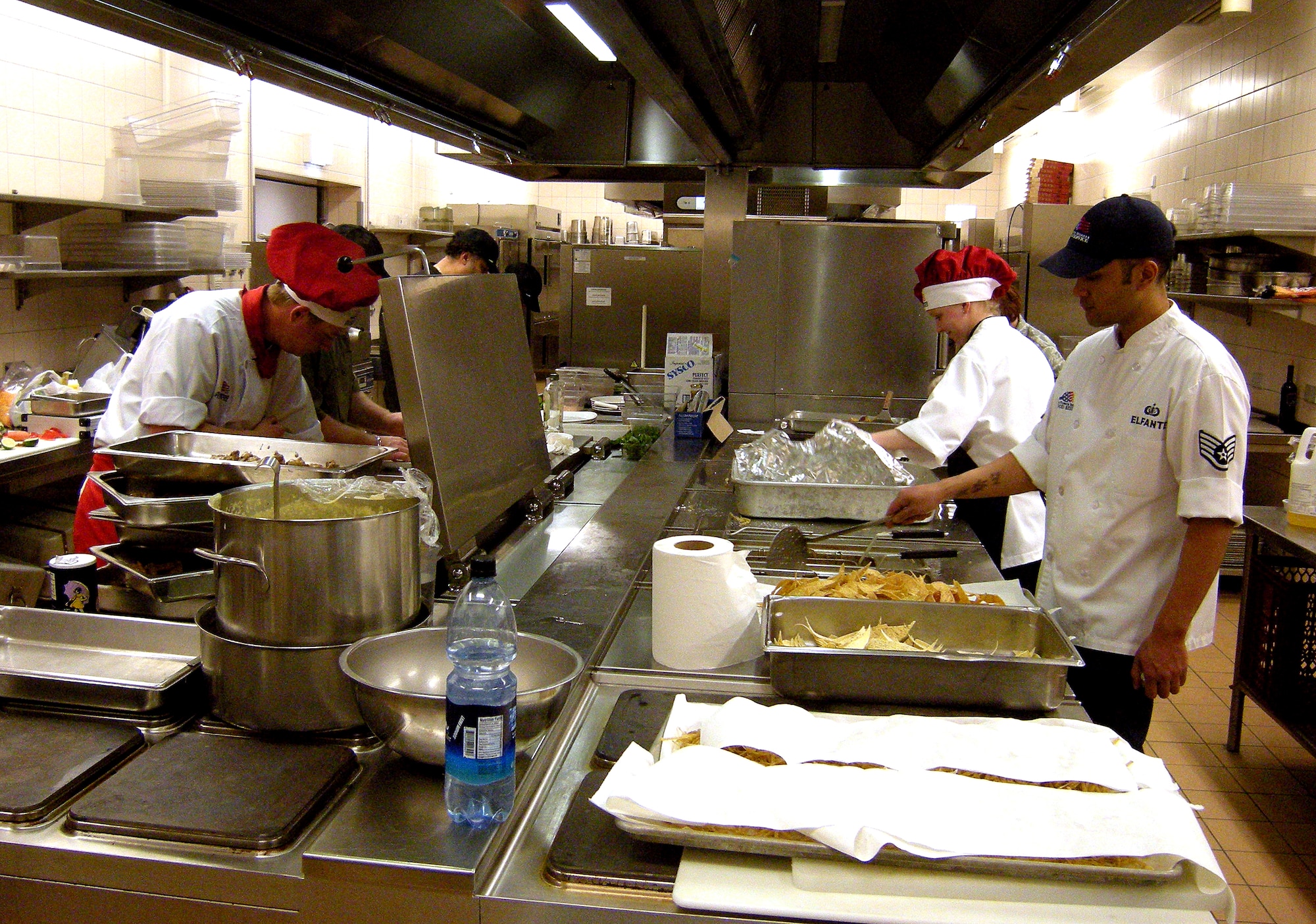 SPANGDAHLEM AIR BASE, Germany – Chefs from Club Eifel (left) and the dining facility prepare food during the Ultimate Chef Showdown held at Club Eifel May 13. The base’s two largest food service agencies competed for the ultimate chef title and trophy.  Club Eifel’s team prepared Italian cuisine and the dining facility team made a Mexican-themed meal. The overall winner was Club Eifel, while the dining facility was commended for having the best appetizer and dessert.   (U.S. Air Force photo/2nd Lt. Kathleen Polesnak)