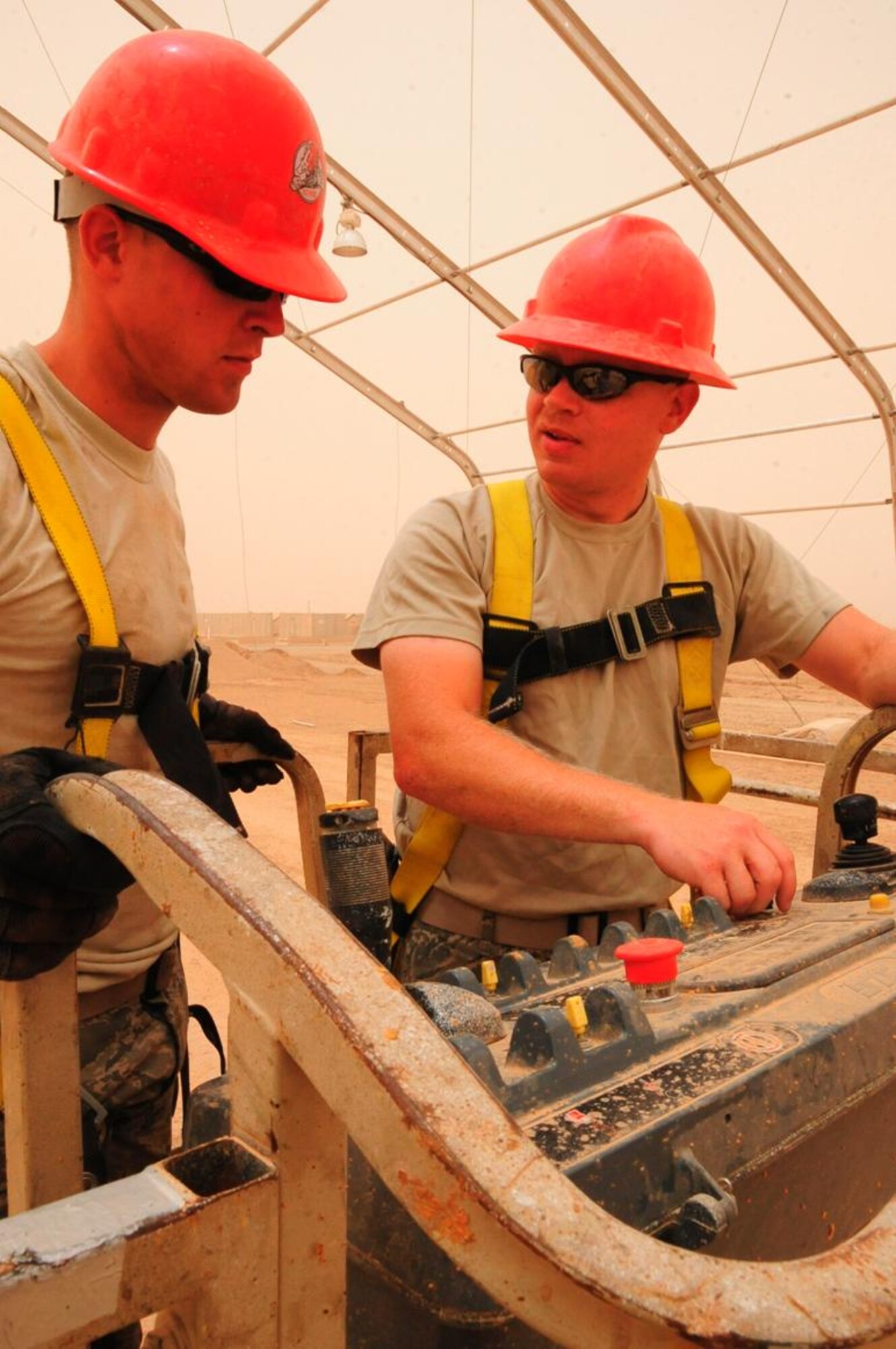 Senior Airman David Schrock, Heavy Equipment Operator deployed from Nellis AFB (L) and Tech. Sgt. Clayton Heimert from Camp Perry, Ohio ANG Base, review operating procedures for a four-wheel drive service platform at Ali Base, Iraq, May 14, 2010.  (U.S. Air Force photo by Master Sgt. Darrell Habisch/released)
