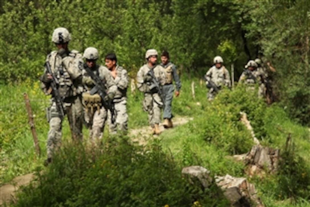 U.S. Army soldiers and Afghan national police officers walk down a path while on their way into the village of Sequala, Jalrez District, Wardak province, Afghanistan, May 11, 2010. This combined forces patrol is going to communicate with and help maintain good relations with the locals. The U.S. soldiers are assigned to the 1st Platoon, 401st Military Police Company.