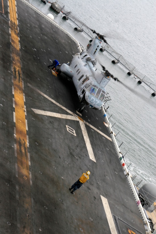 A CH-46E Sea Knight from Marine Medium Helicopter Squadron 165 (Reinforced), 15th Marine Expeditionary Unit, lands on the flight deck of USS Peleliu for embarkation before deploying with the 15th MEU for the last time. The MV-22 Osprey will replace the CH-46E on future deployments.