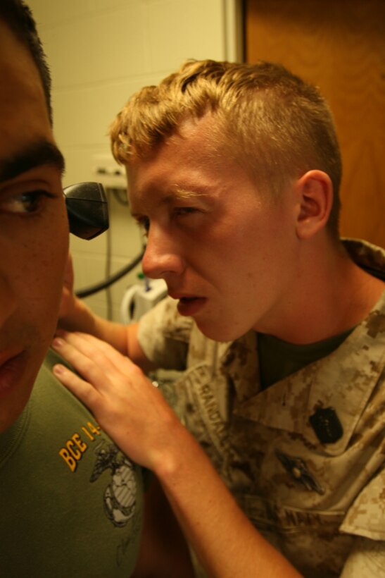 Petty Officer 3rd Class, Curtis J. Randall, Headquarters and Support Company, 7th Engineer Support Battalion, 1st Marine Logistics Group looks into the ear of Lance Cpl. Juan L. Celis at the 7th Engineer Support Battalion, Battalion aid station here, May 17.