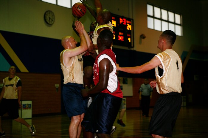 Goon Squad defenders Nathan Daniels and Hubert Louis use their size and power to force William Chatman, Ready Group shooting guard, to take a shot from the perimeter under pressure during a intramural basketball game at IronWorks Gym here Monday. The Goon Squad’s defense forced the Ready Group behind the 3-point arc all night, and in the end the Ready Group’s shooting came up begging leaving them down 48-40 at the buzzer.