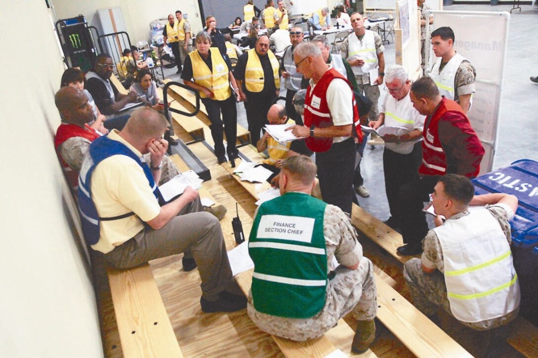 Leaders from all sections within the emergency operations center at 4th Tank Battalion’s headquarters building hold a meeting to discuss the current situation after a notional earthquake struck the Combat Center May 18 during the annual California-wide Exercise Golden Guardian.