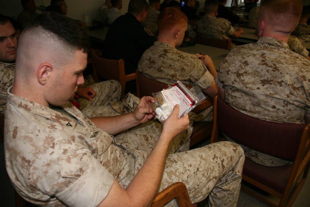 Lance Cpl. Michael P. Bigelow, a military police officer with Headquarters and Headquarters Squadron, inspects a bag of “spice” during a hands-on class for prohibited substances relating to “spice” at the air station’s Provost Marshal’s Office, May 18. During the class, military and civilian police officers burned, felt, and smelled “spice” to better prepare them to recognize the illegal substance during a search.