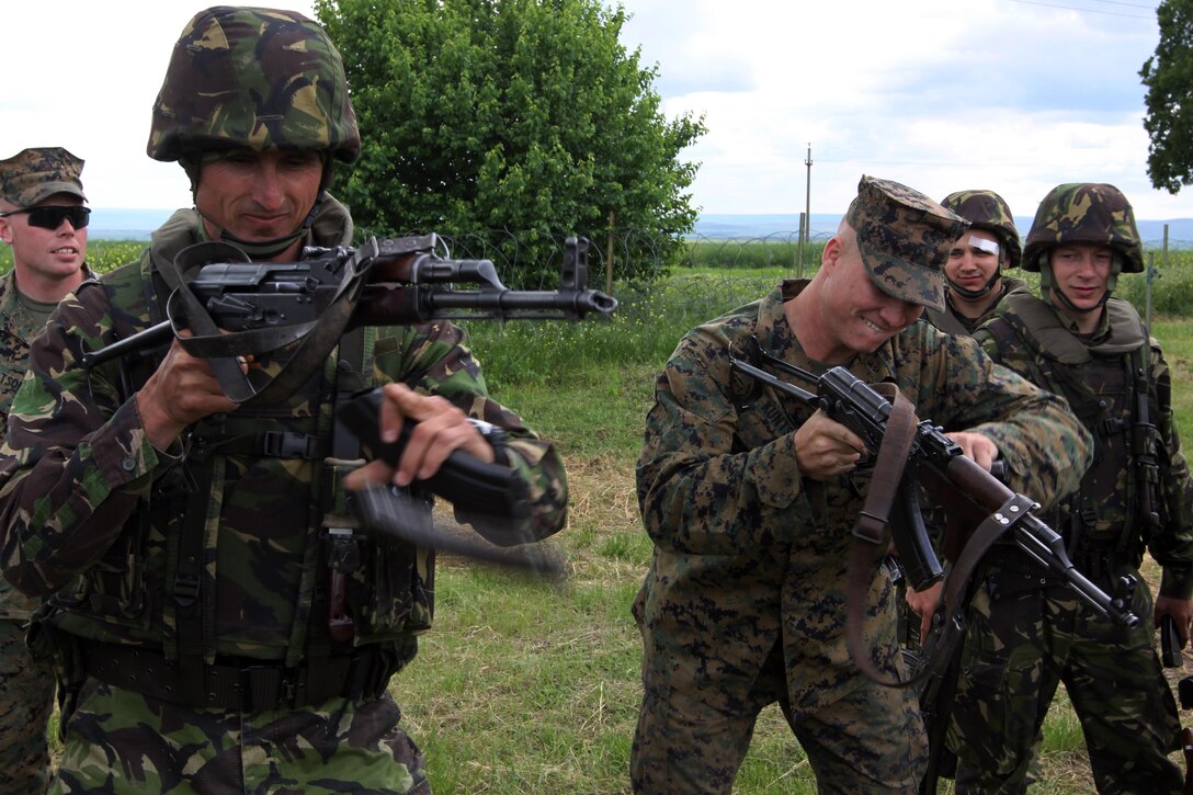 A Romanian Marine and Lance Cpl. Kevin Kuntshick, a tank crewman with scout platoon, Headquarters and Service Company, 1st Tank Battalion, compete in a speed reload competition with AK-74 rifles at Babadag Training Area, Romania, May 18. 1st Tanks Battalion is currently deployed as the core Security Cooperation Marine Air-Ground Task in support of Black Sea Rotational Force.