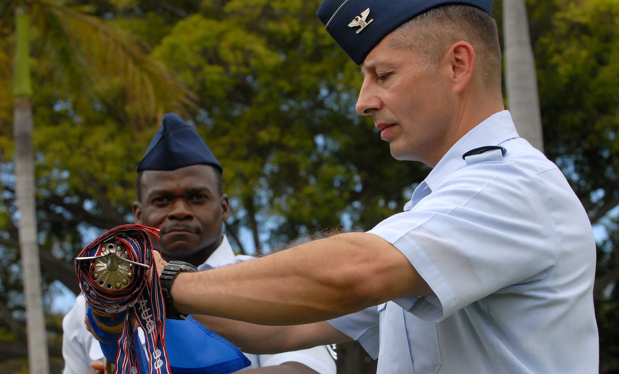 JOINT BASE PEARL HARBOR HICKAM, Hawaii -- Col. Rusty Baumgardner, 674th Mission Support Group commander, rolls up the 15th Mission Support Group guidon during the 15th Wing change of command ceremony May 18. The change of command also included a re-designation from the 15th Airlift Wing to the 15th Wing. The re-designation reflects the mission change of the 15th Wing that will activate an active duty F-22 squadron and KC-135 squadron this summer. (U.S. Air Force photo/Staff Sgt. Mike Meares)