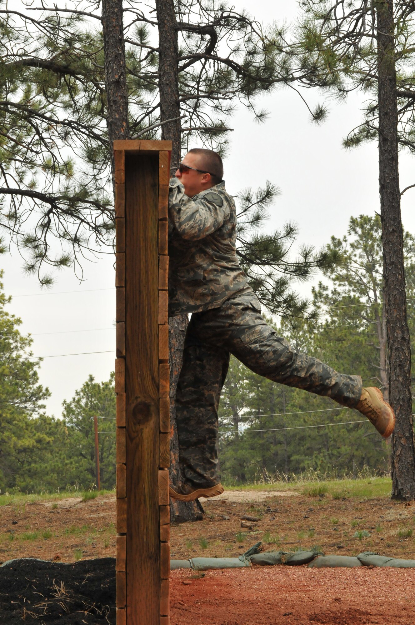 Department of Defense Officer Steven Haymes jumps up a wall during a practice run on the Assault Course at the U.S. Air Force Academy, Colo., May 18, 2010. Officer Haymes is a Guardian Challenge 2010 competitor from the Space and Missile Systems Center's 61st Security Forces Squadron at Los Angeles Air Force Base. (Photo by Lou Hernandez)