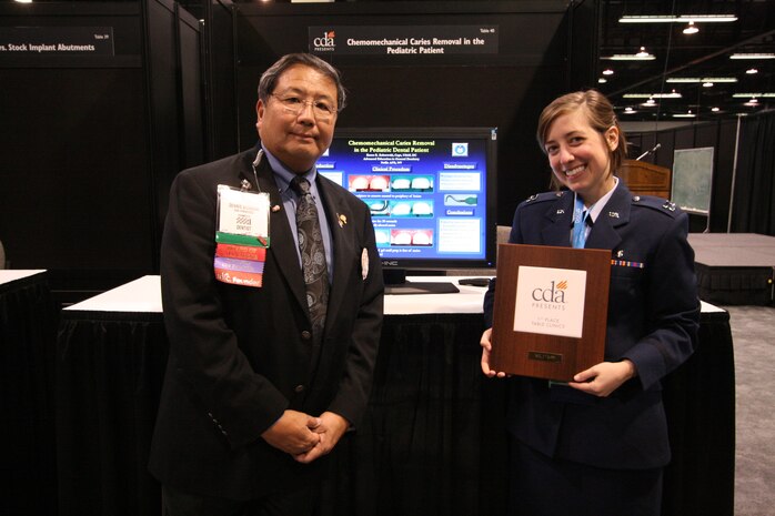 NELLIS AIR FORCE BASE, Nev. – Dr. Dennis Shinbori, a California Dental Association board member, presents Capt. (Dr.) Karen Zabrowski, a resident dentist at the Advanced Education of General Dentistry course at Nellis, the first place certificate for its annual table clinic competition. Dr. Zabrowski was awarded first place out of 44 delegates from the Air Force, Navy and Veteran’s Affairs, for her presentation on the removal of “Chemomechanical Caries in Pediatric Patients.” (courtesy photo)