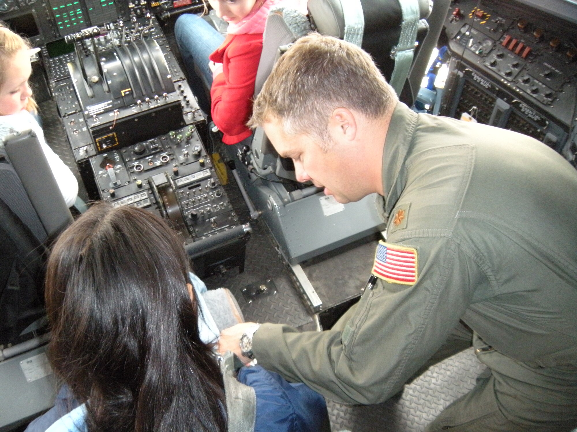Maj. Brad James, an Air Force Reserve C-130 pilot assigned to the 731st Airlift Squadron, helps a student buckle into a flight engineer's seat May 18 at Peterson Air Force Base, Colo. The student was one of 11 from the Colorado Springs School that visited the 302nd Airlift Wing where they learned about aeronautics, the C-130 Hercules and the aerial firefighting mission of the wing. The students' visit was part of an eight-day learning excursion on the subject of aeronautics. The 302nd Airlift Wing is an Air Force Reserve Command unit based in southern Colorado. (U.S. Air Force photo/Staff Sgt. Stephen J. Collier)
