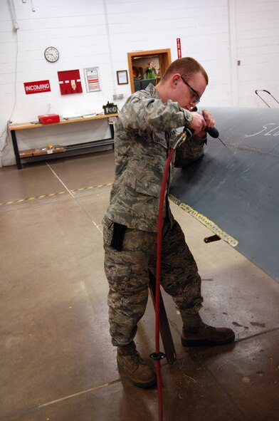 MINOT AIR FORCE BASE, N.D. -- Airman 1st Class David Bellone 5th Maintenance Squadron aircraft structural maintenance journeyman, replaces rivets from a lower body cowl here May 13.  The 5th MXS supports the 5th Bomb Wing by providing equipment maintenance on its B-52H Stratofortresses. (U.S. Air Force photo by Airman 1st Class Aaron-Forrest Wainwright)