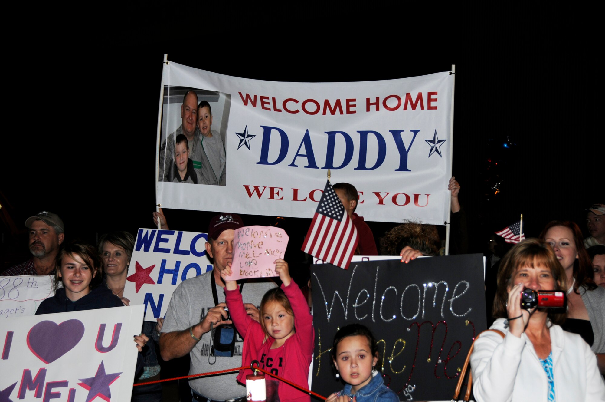Family members of deployed 188th Fighter Wing Airmen hold up signs during a homecoming gathering at the Fort Smith (Ark.) Air National Guard unit to welcome back the Guardsmen, who were deployed to Kandahar Airfield in Afghanistan. More than 200 Airmen returned May 17. (U.S. Air Force photo by Tech Sgt. Stephen Hornsey/188th Fighter Wing Public Affairs)