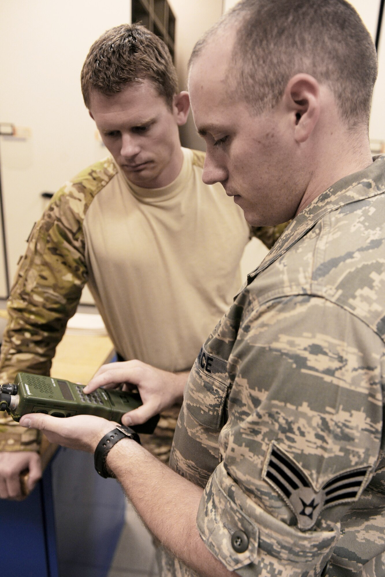 Senior Airman Jacob Manee explains the different functions of a personal radio to a 38th RQS pararescueman before an exercise mission May 12, 2010, at Moody Air Force Base, Ga. Airman Manee is a 38th Rescue Squadron logistics flight communications member. (U.S. Air Force photo/Airman 1st Class Benjamin Wiseman)