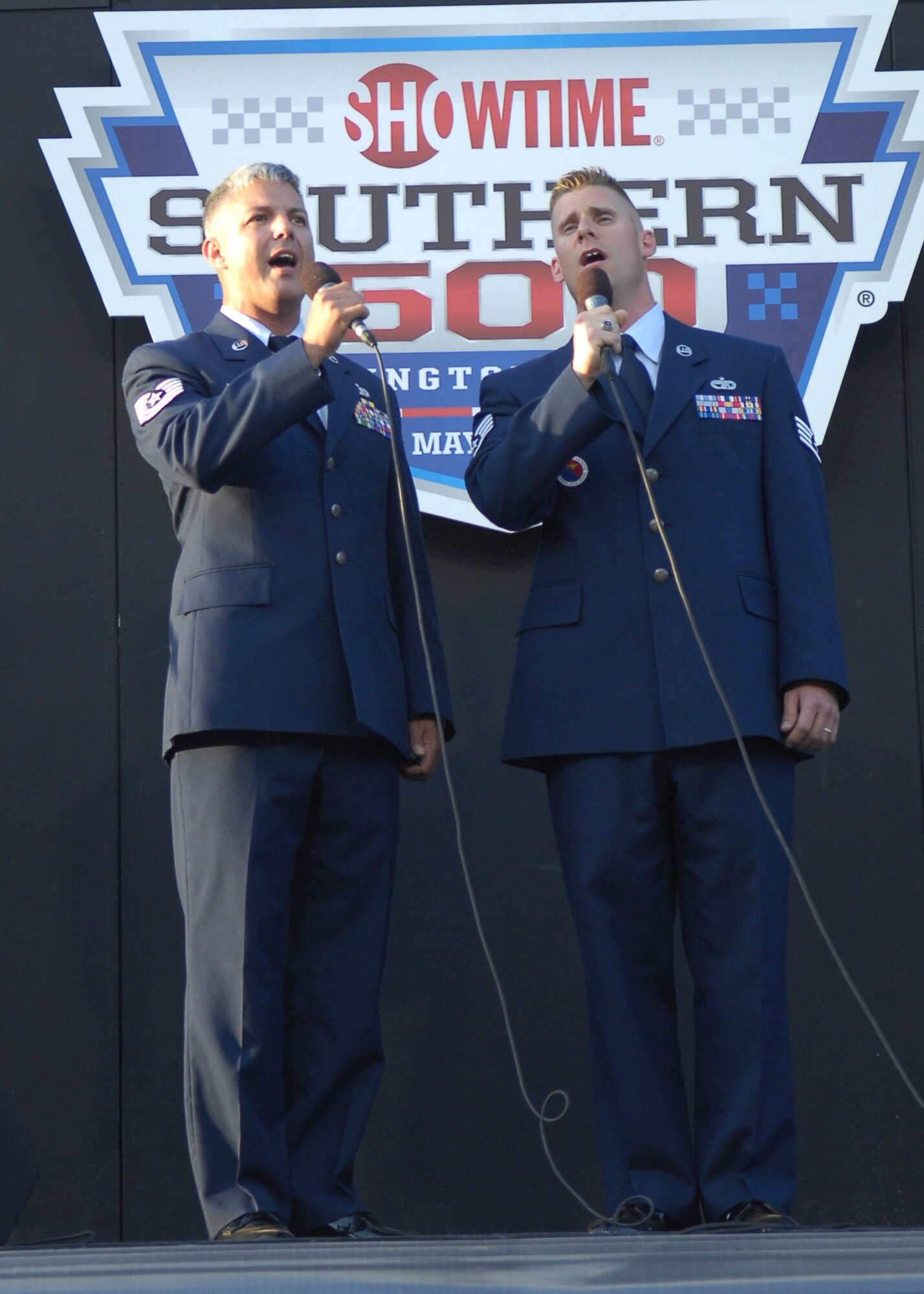 Tech. Sgt. John Norman, 3rd Aerial Port Squadron, and Staff Sgt. Kenneth Shelton, 43rd Force Support Squadron, sing the National Anthem at the SHOWTIME Southern 500 NASCAR race at Darlington Raceway in Darlington S.C. on May 8. (U.S. Air Force photo/2nd Lt. Cammie Quinn)