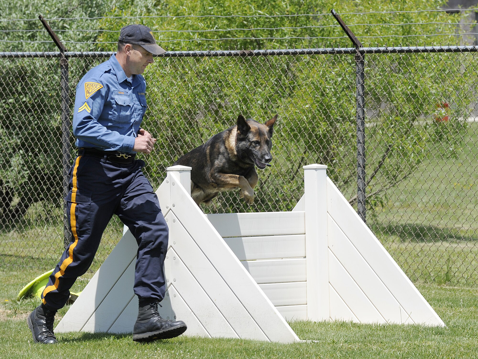 Sean Dawson, K-9 Unit South Region assistant squad leader, leads his dog Rip through a obstacle course during the obedience portion of the K-9 competition at Joint Base McGuire-Dix-Lakehurst May 13. Various activities were held throughout JB MDL as part of National Police Week, which is held annually across the nation. (U.S. Air Force photo/Carlos Cintron)
