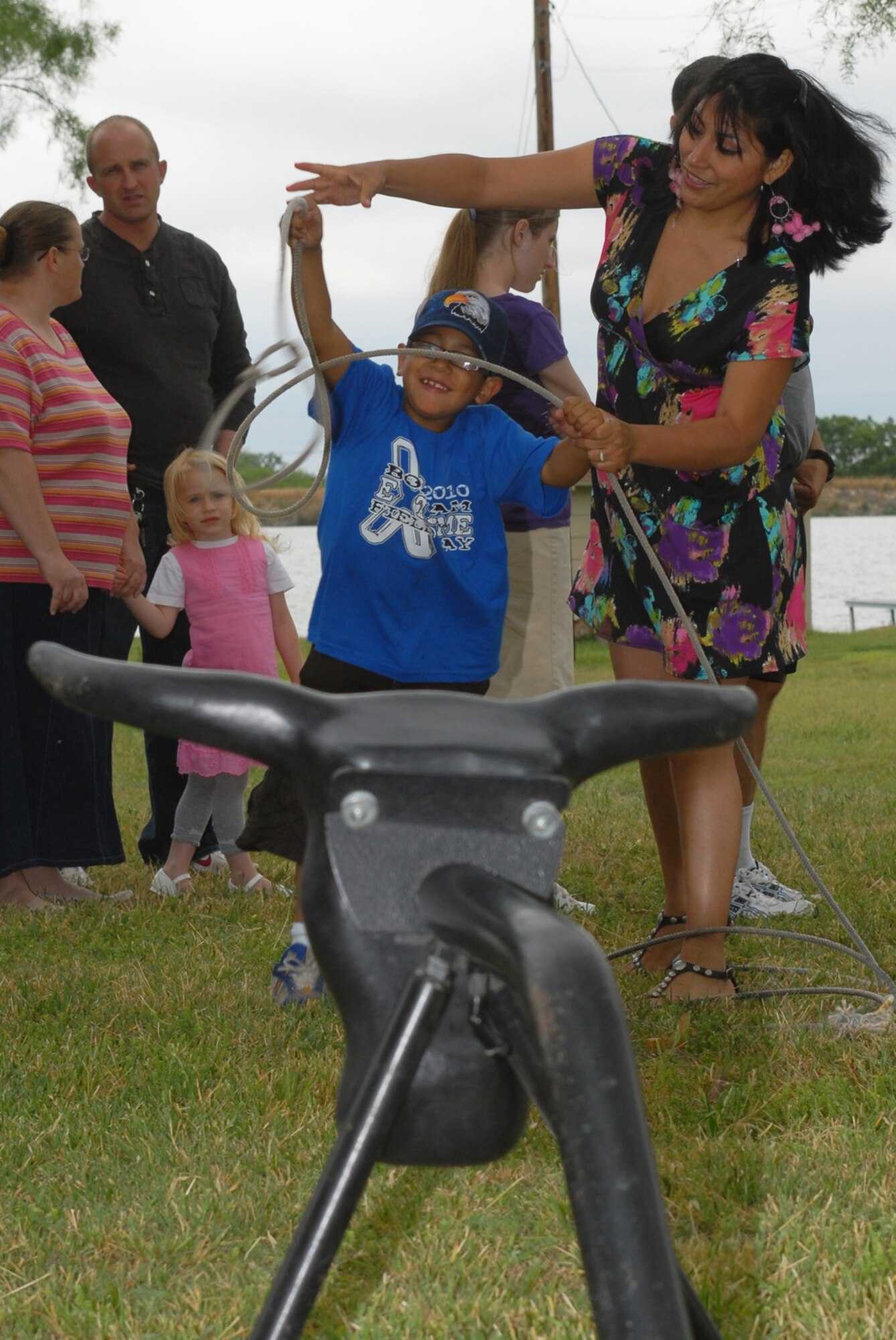 SAN ANGELO, Texas -- Gladys Crocitta shows her 7-year-old son Toshio how to rope a bull during the 5th Annual Military Appreciation Day, May 15, 2010. Ms. Crocitta is the wife of Army Pfc. Chris Crocitta, a student with the 344th Military Intelligence Battalion. The event, held at the Goodfellow Air Force Base Recreation Camp, was hosted by the San Angelo Chamber of Commerce. (U.S. Air Force photo/Staff Sgt. Laura R. McFarlane)

