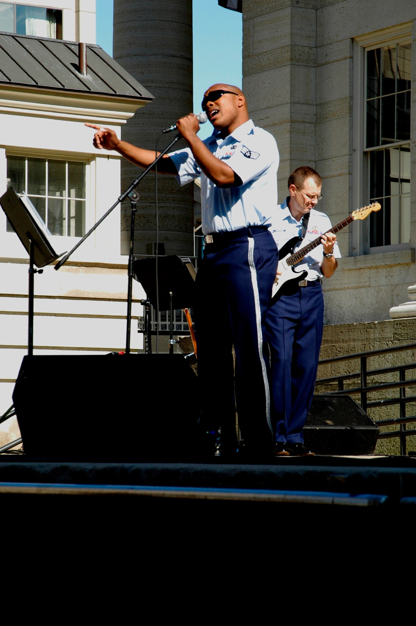 Senior Airman Andrew Jones of the New Harmony band from Wright-Patterson AFB, Ohio, sings “Living in America” by James Brown to a downtown Dayton crowed at Urban Nights while guitar player Technical Sgt. Cameron Voorhees plays the upbeat rhythm. (U.S. Air Force photo by Ted Theopolos) 