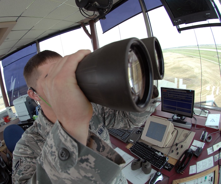 MINOT AIR FORCE BASE, N.D. – Airman 1st Class Thomas Jirkovsky, 5th Operations Support Squadron air traffic control apprentice, uses binoculars ensure the safety of the flight line prior to a plane landing here May 12. Air traffic controllers operate air traffic systems to expedite and maintain a safe, orderly flow of air traffic as well as flight line activity. (U.S. Air Force photo by Senior Airman Jesse Lopez)