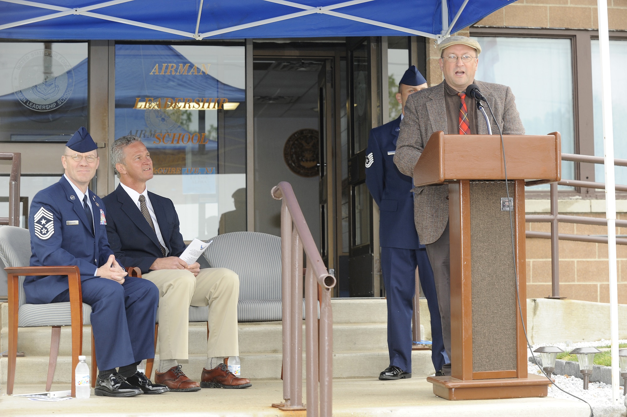 Gary W. Boyd, Air Force History and Museum programs director, speaks to a large crowd during the Airmen Leadership School building dedication here May 12 as Chief Master Sgt. Lee Wofford, 87th ABW Command Chief, and Ed Kish, son of Tech Sgt. Frank Z. Kish, listen to the historic speech. The ALS building was renamed “Kish Airman Leadership School” in memory of Tech. Sgt. Frank Z. Kish who served  in World War II as a maintenance professional and crew chief for Maj. Thomas B. McGuire in the Southwest Pacific. (U.S. Air Force photo/Carlos Cintron) 
