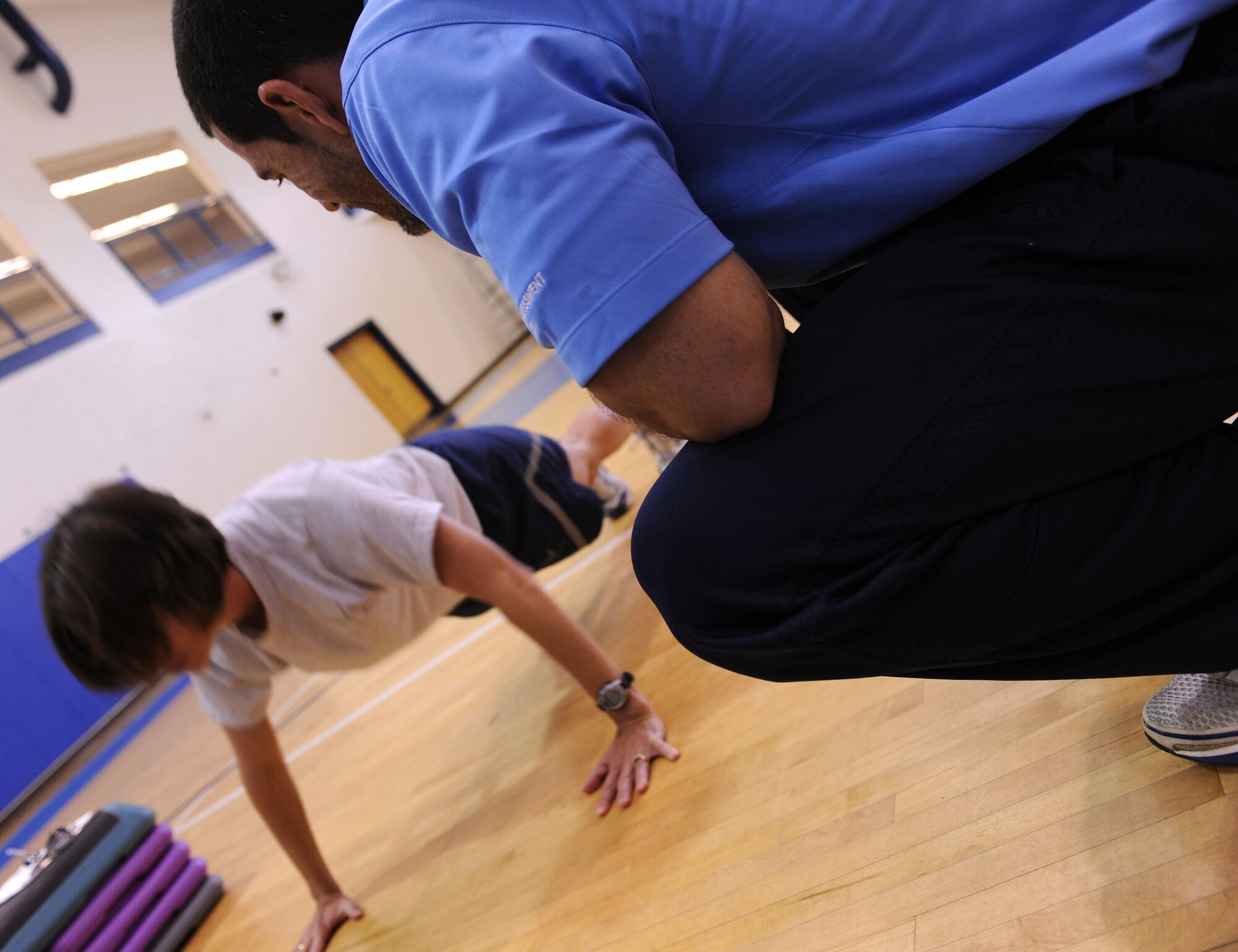 LANGLEY AIR FORCE BASE, Va. -- Tony Arroyo, 633d Force Support Squadron fitness testing technician, observes Senior Airman Cynthia Ramirez, USAF Heritage of America Band clarinetist, push-ups during the fitness assessment demonstration May 17. The demonstration is designed to prepare personnel for the transition to Fitness Assessment Cell testing in July. (U.S. Air Force Photo/Staff Sgt. Christina M. Styer) 