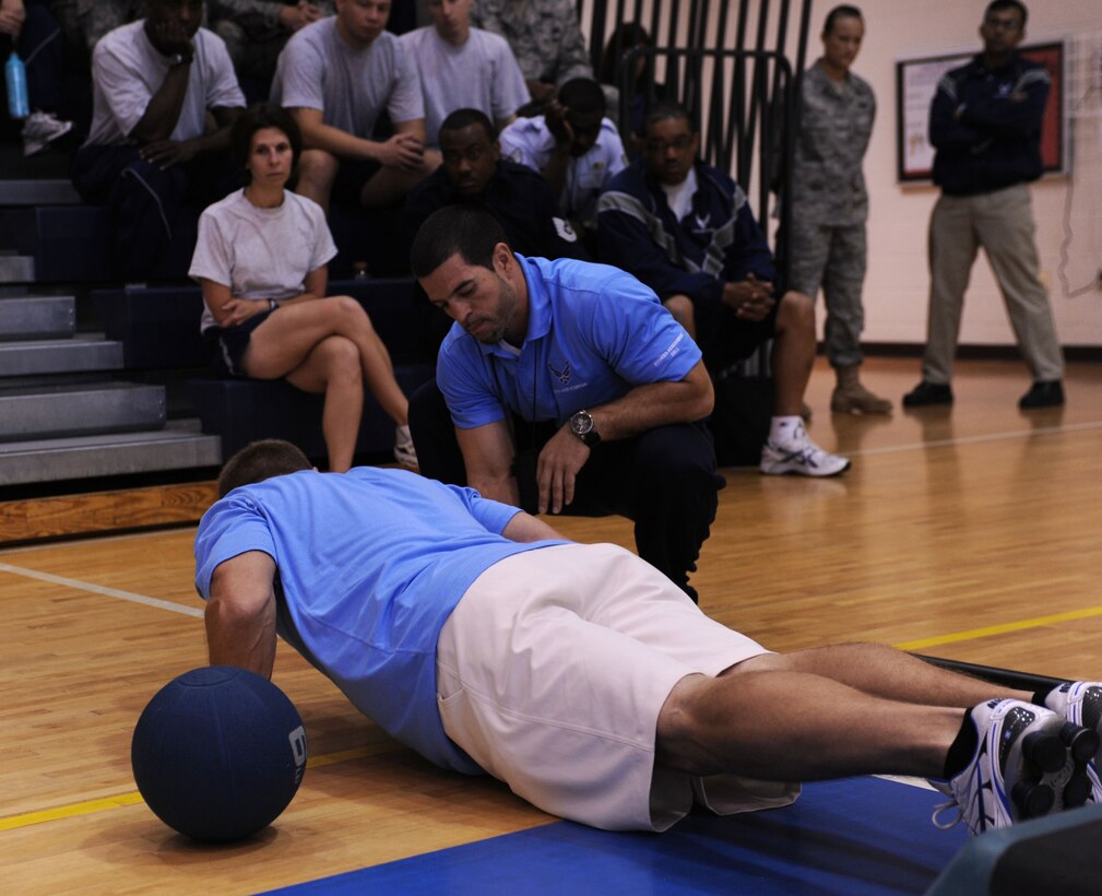 LANGLEY AIR FORCE BASE, Va. -- Tony Arroyo and Chris Bendix, 633d Force Support Squadron fitness testing technicians, demonstrate proper push-up form during the fitness assessment demonstration May 17. The demonstration is designed to prepare personnel for the transition to Fitness Assessment Cell testing in July. (U.S. Air Force Photo/Staff Sgt. Christina M. Styer) 