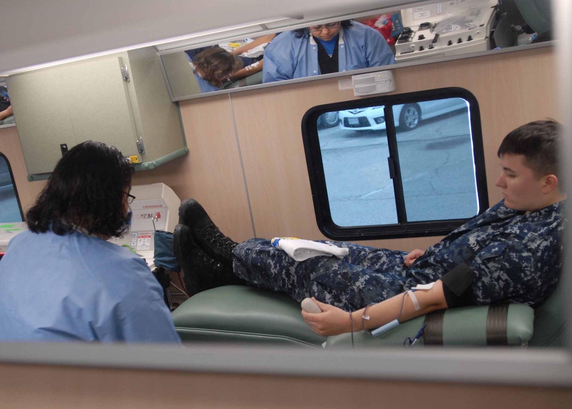 Navy Petty Officer 2nd Class, Lauren Kowalski, Navy Analyst and Reporting Course student, donates one pint of blood, while United Blood Service technician, Stacy Trevino observes, during a blood drive in the commissary parking lot, May 14. Donating blood is something Petty Officer Second Class Kowalski believes is the right thing to do and has donated at least 20 times since she was 15 years old. (U.S. Air Force photo/ Senior Airman Tong Duong)