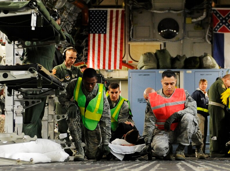SCOTT AIR FORCE BASE, Ill. -- Aeromedical Staging Flight personnel transport wounded servicemembers from a C-17 Globemaster III onto buses to be transported to the ASF at Scott Air Force Base, May 15, 2010. The ASF at Scott serves as a transport hub for wounded servicemembers coming from overseas. The team here is responsible for picking up, housing, treating and moving the patients onward to their final location. (U.S. Air Force photo/ Senior Airman Ryan Crane)
