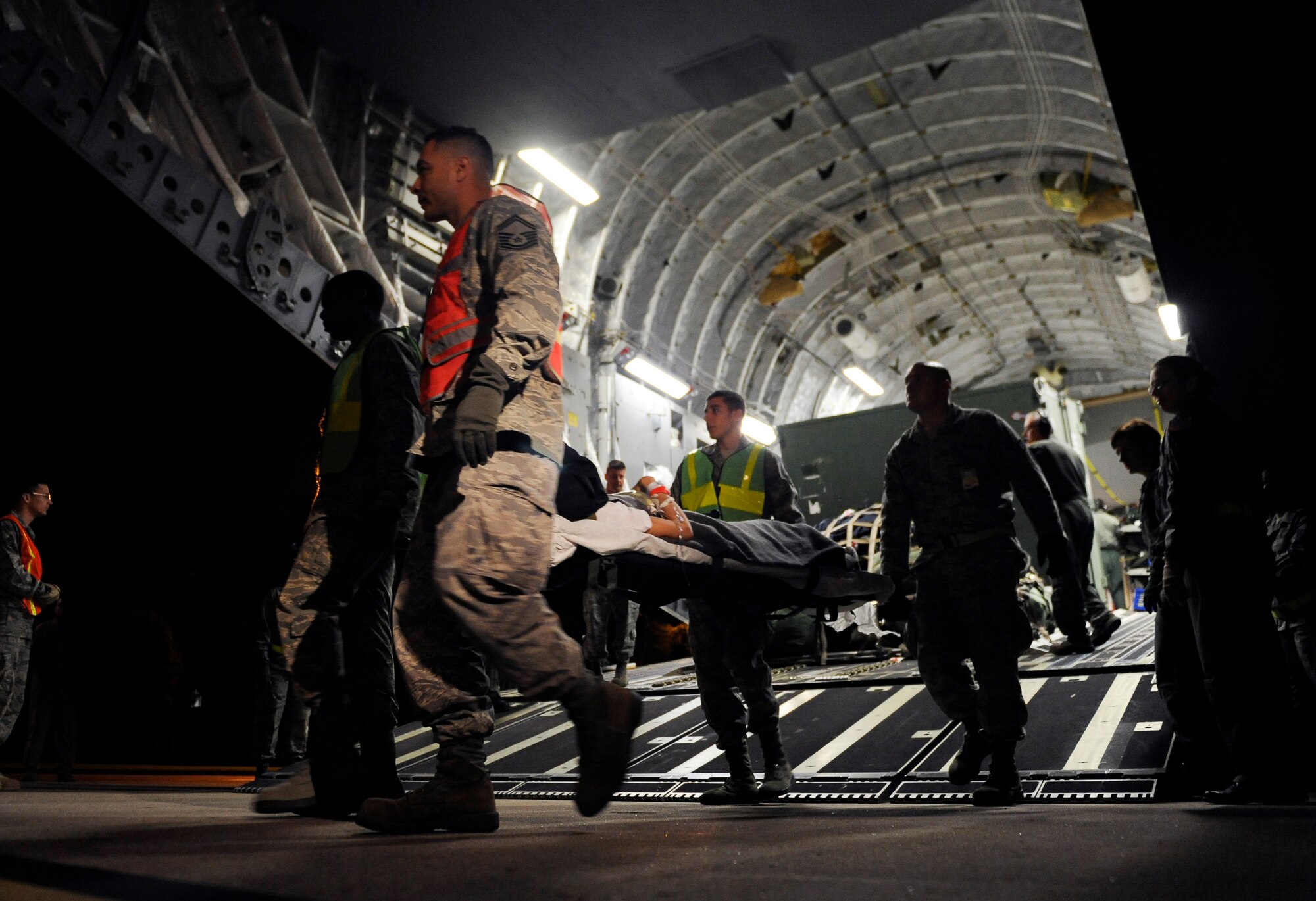SCOTT AIR FORCE BASE, Ill. -- Aeromedical Staging Flight personnel transport wounded servicemembers from a C-17 Globemaster III onto buses to be transported to the ASF at Scott Air Force Base, May 15, 2010. The ASF at Scott serves as a transport hub for wounded servicemembers coming from overseas. The team here is responsible for picking up, housing, treating and moving the patients onward to their final location. (U.S. Air Force photo/ Senior Airman Ryan Crane)