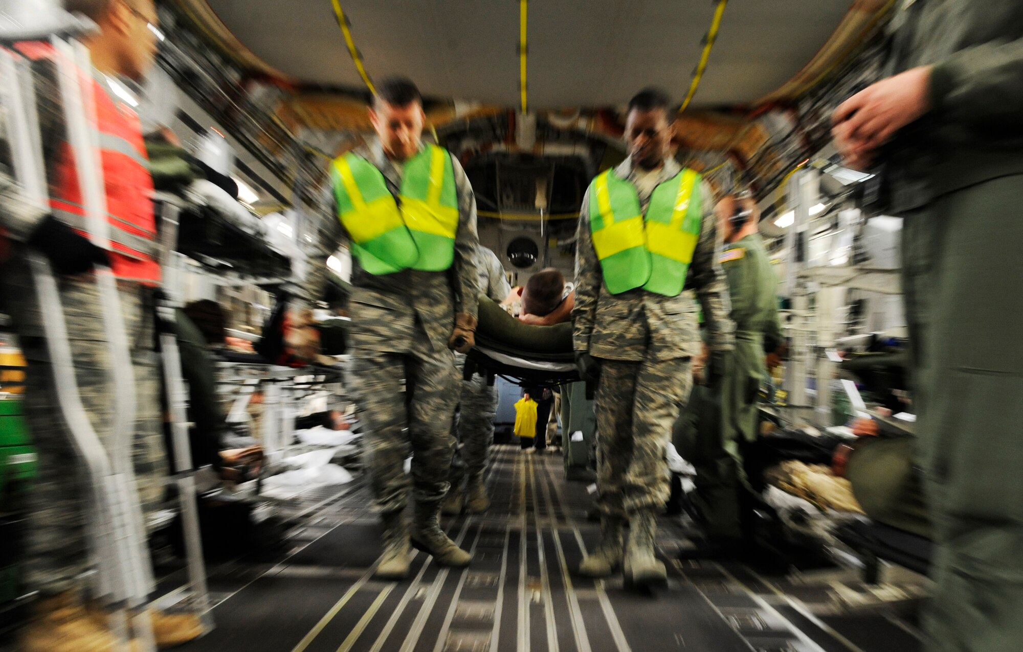 SCOTT AIR FORCE BASE, Ill. -- Aeromedical Staging Flight personnel transport wounded servicemembers from a C-17 Globemaster III onto buses to be transported to the ASF at Scott Air Force Base, May 15, 2010. The ASF at Scott serves as a transport hub for wounded servicemembers coming from overseas. The team here is responsible for picking up, housing, treating and moving the patients onward to their final location. (U.S. Air Force photo/ Senior Airman Ryan Crane)