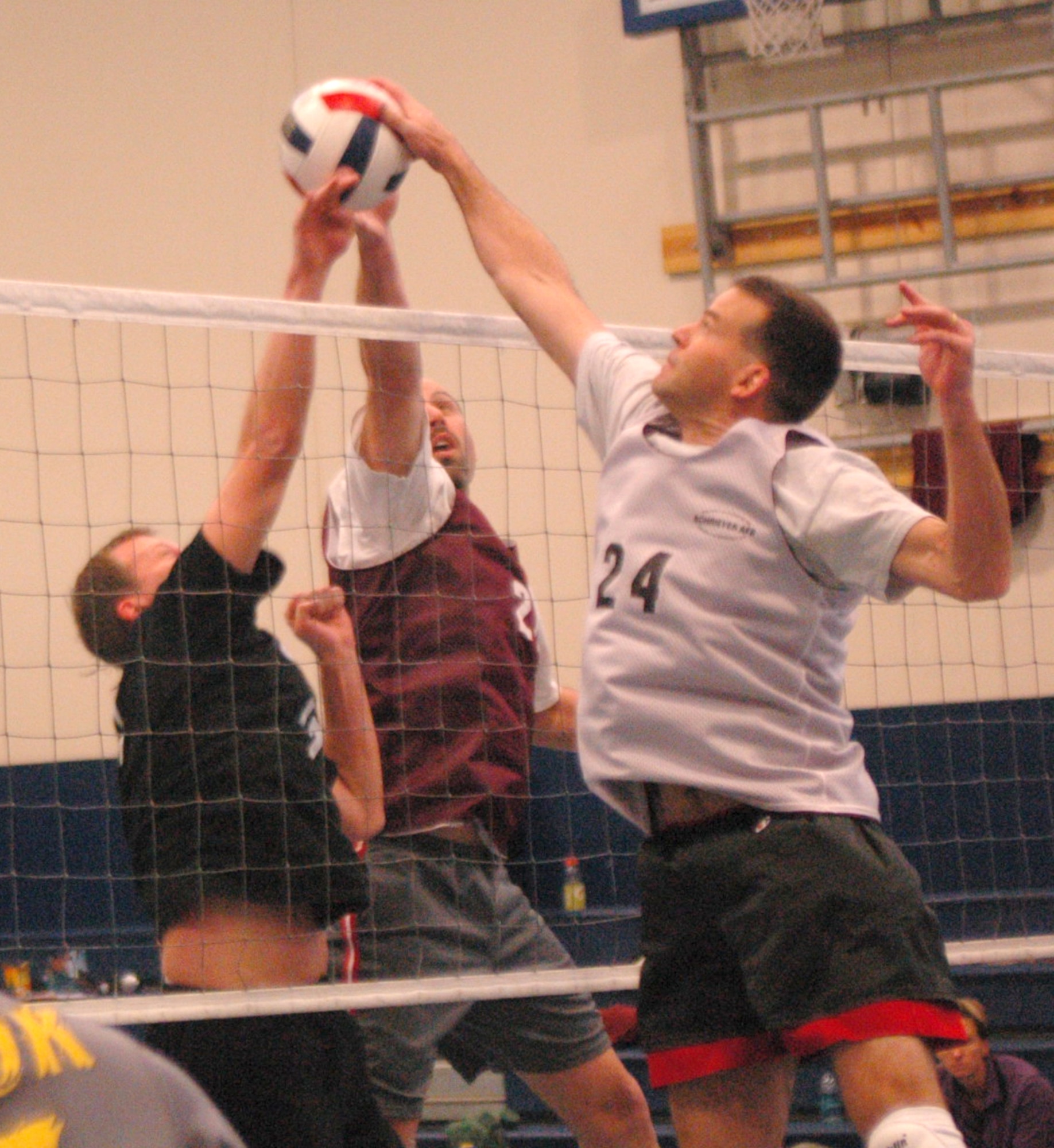 SCHRIEVER AIR FORCE BASE, Colo. -- Team Schriever's Bill Witwicky and Craig Armogida battle a Team Peterson player for control at the net during round-robin play in the Rocky Mountain Volleyball Championships at the fitness center here. (U.S. Air Force photo/Scott Prater)