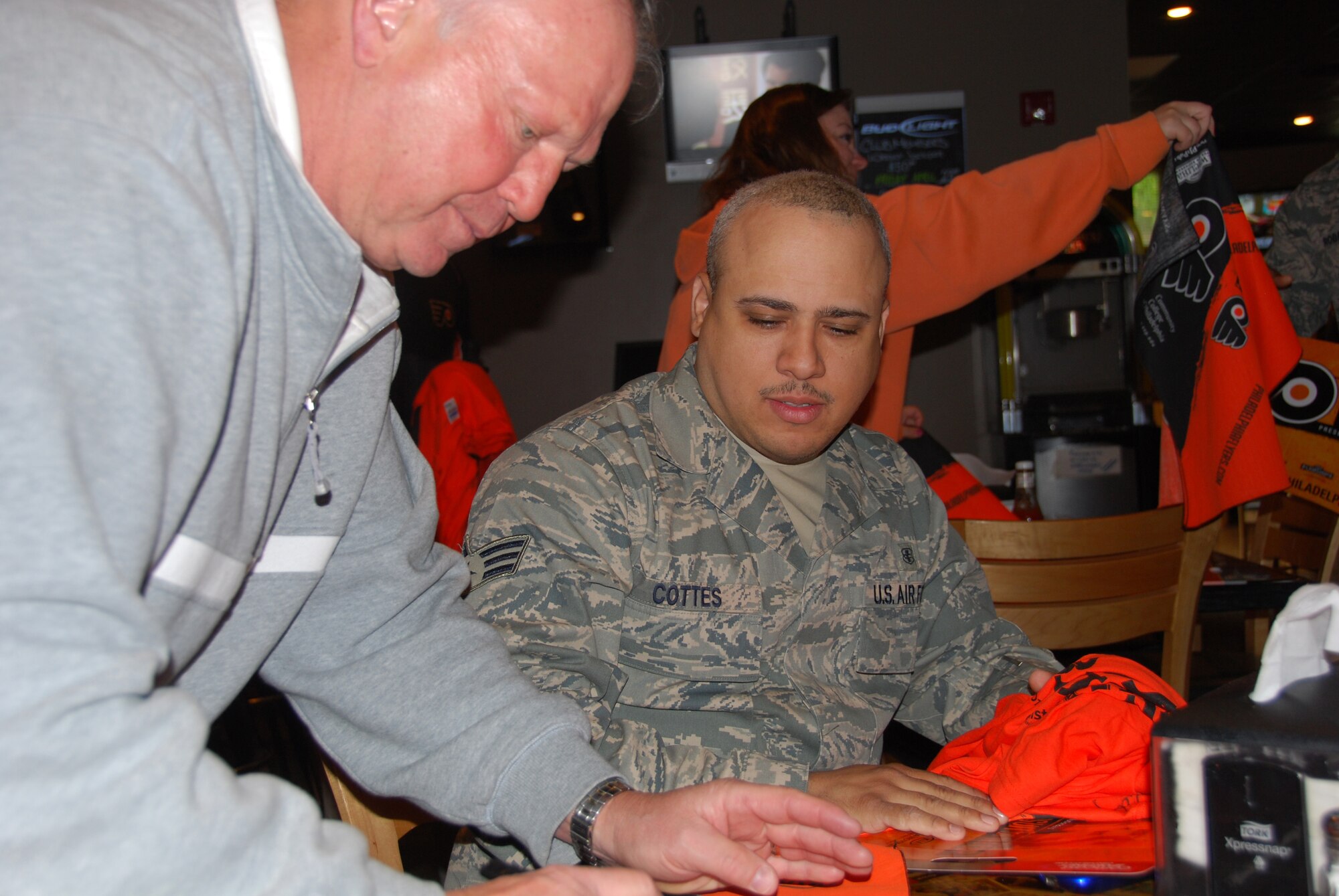 JOINT BASE MCGUIRE-DIX-LAKEHURST, N.J. - Bob "The Hound" Kelly, former NHL Philadelphia Flyer's forward, visited Joint Base McGuire-Dix-Lakehurst recently to learn more about the base's many missions. Senior Airman Samuel Cottes was one of many Flyer's fans to come out to meet the two-time Stanley Cup Champion and pick up a few Flyer's mementos. (U.S. Air Force photo/Master Sgt. Donna T. Jeffries)