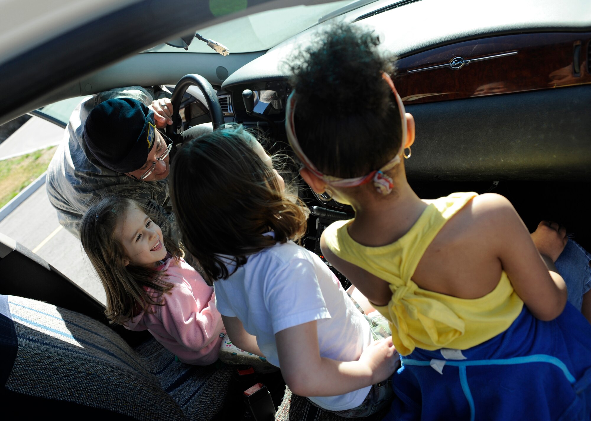 Technical Sgt. Cody Belt shows three children how to operate the sirens of a patrol vehicle May 14, 2010, Eielson Air Force Base, Alaska. Sergeant Belt was participating in Police Appreciation and Safety Awareness Day, a joint safety day where various base units set up stations for children to learn about safe practices and those who uphold their daily safety. Sergeant Belt is assigned to the 354th Security Forces Squadron. (U.S. Air Force photo/Airman 1st Class Willard E. Grande II)