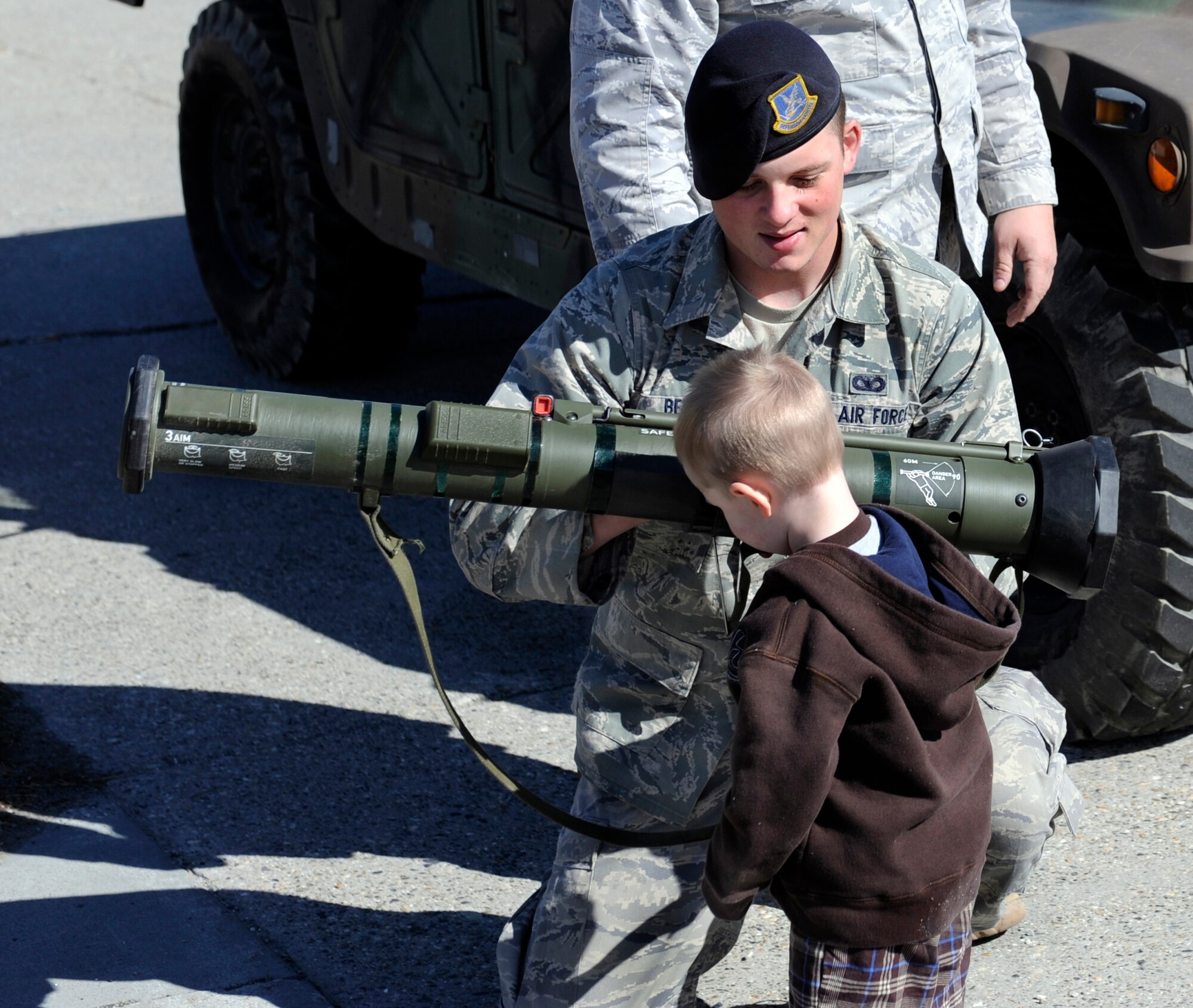 Airman Basic Zachary Bert displays an AT4 to a young child May 14, 2010, Eielson Air Force Base, Alaska. Airman Bert was participating in Police Appreciation and Safety Awareness Day, a joint safety day where various base units set up stations for children to learn about safe practices and those who uphold their daily safety. Airman Bert is assigned to the 354th Security Forces Squadron. (U.S. Air Force photo/Airman 1st Class Willard E. Grande II)