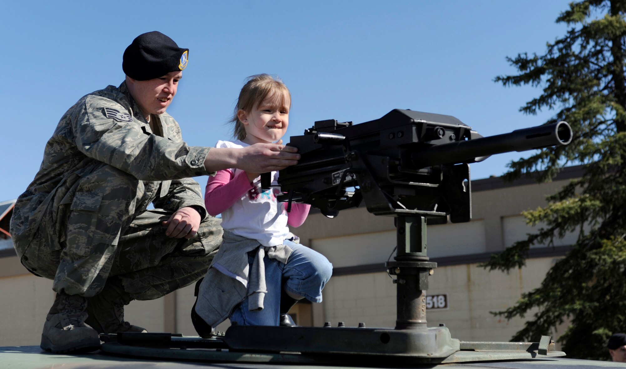 Staff Sgt. Justin Rawls shows a young girl a Mk-19 grenade launcher May 14, 2010, Eielson Air Force Base, Alaska. Sergeant Rawls was participating in Police Appreciation and Safety Awareness Day, a joint safety day where various base units set up stations for children to learn about safe practices and those who uphold their daily safety. Sergeant Rawls is assigned to the 354th Security Forces Squadron. (U.S. Air Force photo/Airman 1st Class Willard E. Grande II)