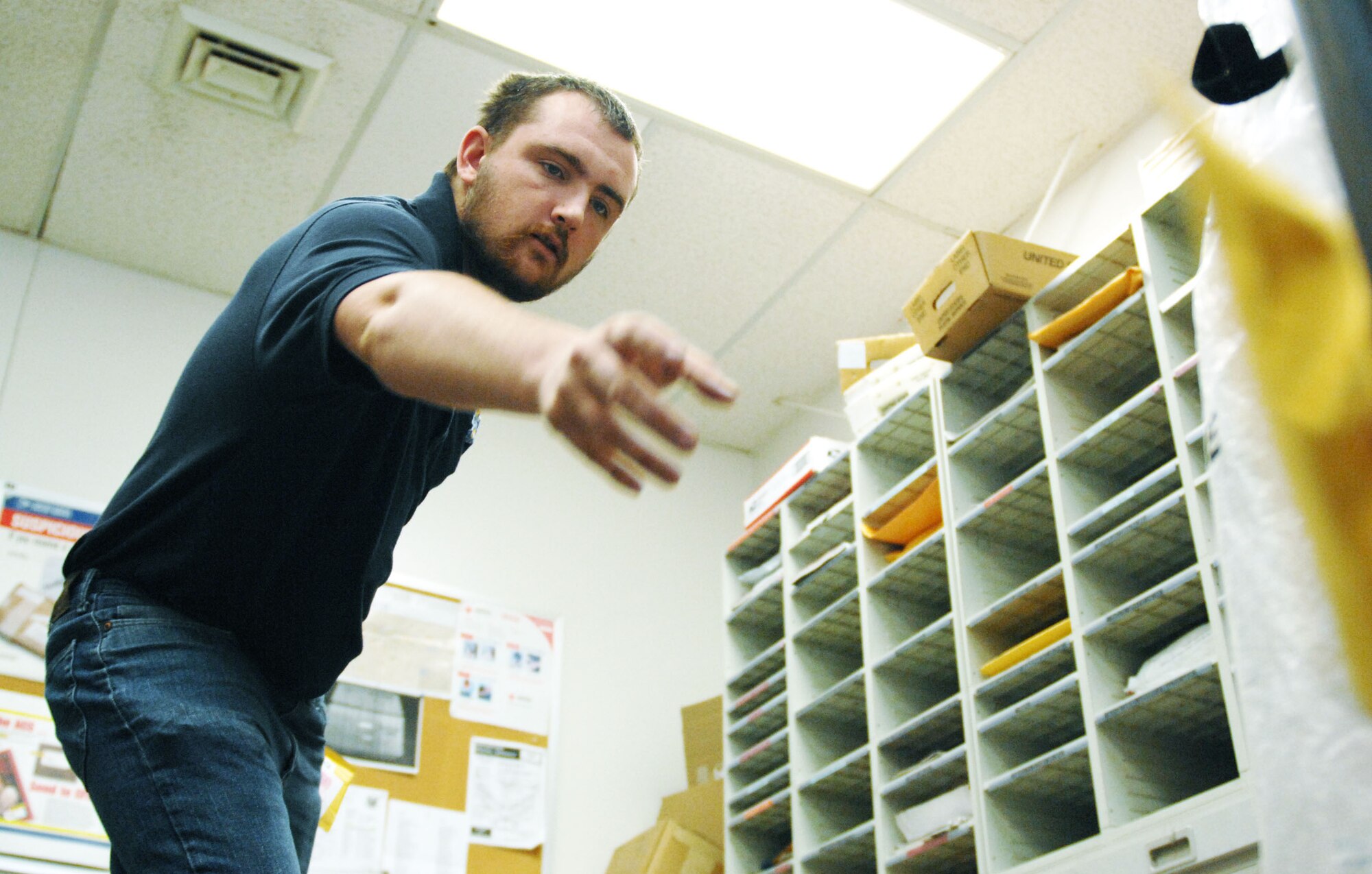 Donald Morris Jr., an employee at the Official Mail Center, sorts letters and packages that arrived earlier that morning.  After sorting, the mail is distributed around the base.