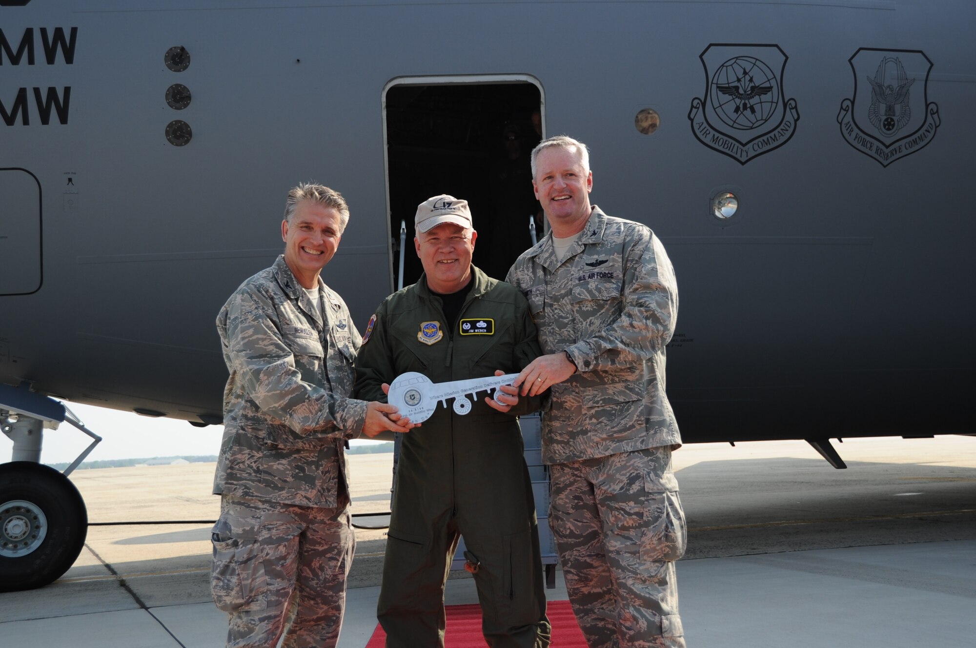 Col. James Weber, 305th Maintenance Group commander, presents Col. Giordano McMullen, 514th Air Mobility Wing commander, and Col. Scott Smith, 305th Air Mobility Wing commander, with a symbolic key to the flightline's newest C-17 Globemaster. This is the first of three new C-17s assigned to JB MDL. The 305th and 514th AMWs are the first to receive the intial round of aircraft scheduled for delivery during the next few weeks. (U.S. Air Force photo/2nd Lt. Carolyn Glover)