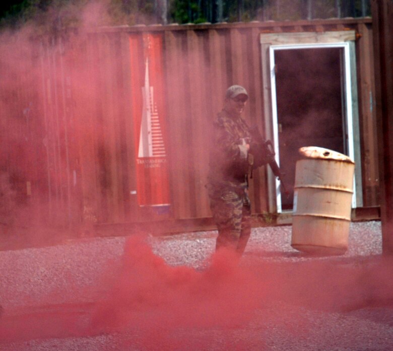 Mathew Comeau, 1st Special Operations Support Squadron Range Support flight opposition forces member, looks through the haze of a recently-used smoke grenade while searching for Survival, Evasion, Resistance and Escape students during combat survival training at an undisclosed location in the Eglin Range, Fla., May 13, 2010. OPFOR provides support capabilities to 1st Special Operations Wing aircraft and ground assets, and, when available, other Air Force Special Operations Command, Air Force and joint partners who request them.  (DoD photo by U.S. Air Force Airman 1st Class Joe McFadden)