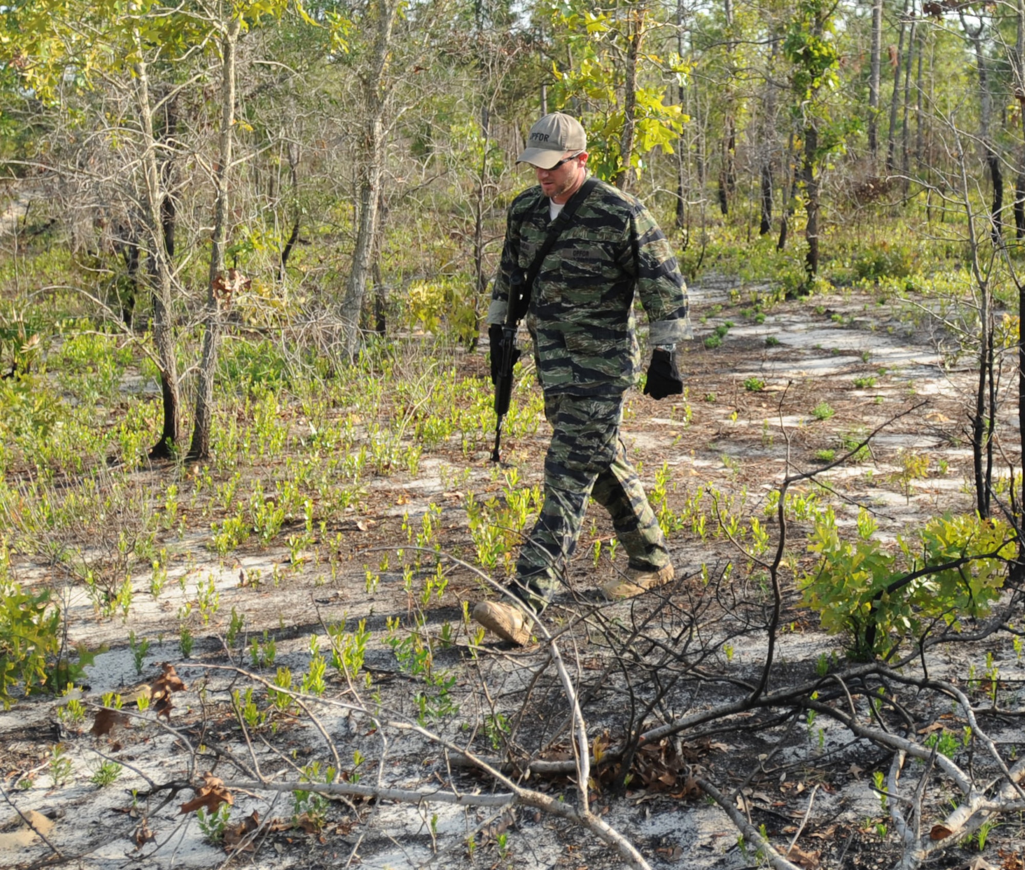Mathew Comeau, 1st Special Operations Support Squadron Range Support flight opposition forces member, scans for tracks from Survival, Evasion, Resistance and Escape students during combat survival training at an undisclosed location in the Eglin Range, Fla., May 13, 2010. OPFOR provides support capabilities to 1st Special Operations Wing aircraft and ground assets, and, when available, other Air Force Special Operations Command, Air Force and joint partners who request them.  (DoD photo by U.S. Air Force Senior Airman Matthew Loken)