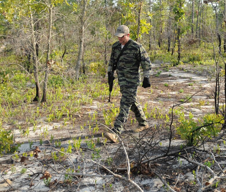 Mathew Comeau, 1st Special Operations Support Squadron Range Support flight opposition forces member, scans for tracks from Survival, Evasion, Resistance and Escape students during combat survival training at an undisclosed location in the Eglin Range, Fla., May 13, 2010. OPFOR provides support capabilities to 1st Special Operations Wing aircraft and ground assets, and, when available, other Air Force Special Operations Command, Air Force and joint partners who request them.  (DoD photo by U.S. Air Force Senior Airman Matthew Loken)