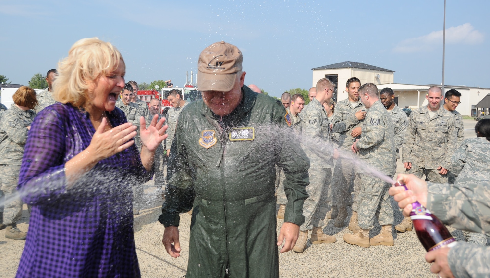 Col. James Weber, 305th Maintenance Group commander, and his wife Denise are sprayed with water and champagne in celebration of Weber's final flight of his career. His final flight before retirement  took place during the inaugural flight of the 305th and 514th Air Mobility Wings' newest C-17 Globemaster. (U.S. Air Force photo/2nd Lt. Carolyn Glover)