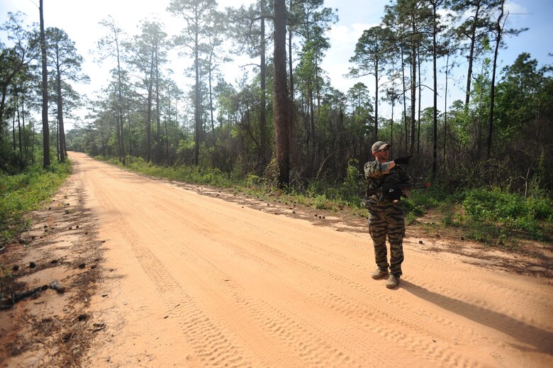 Mathew Comeau, 1st Special Operations Support Squadron Range Support flight opposition forces member, scans the road for footprints during combat survival training at an undisclosed location in the Eglin Range, Fla., May 13, 2010. OPFOR provides support capabilities to 1st Special Operations Wing aircraft and ground assets, and, when available, other Air Force Special Operations Command, Air Force and joint partners who request them.  (DoD photo by U.S. Air Force Senior Airman Matthew Loken)